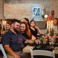 Guests seated at a long dressed table during an evening dinner