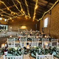 The main hall set with long tables and fairy lights for a formal dinner